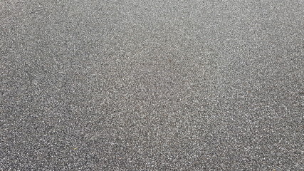 Asphalt from very small stones. Black and white asphalt background. Smooth dark asphalt.