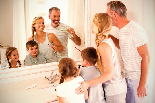 Parents and kids brushing teeth in bathroom