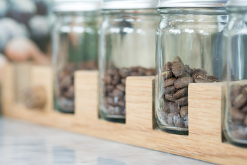 Transparent jars with coffee beans in coffee shop
