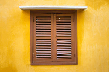 vintage window on yellow wall.