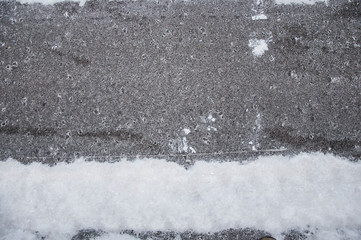 Snow on asphalt, the first snow, city.