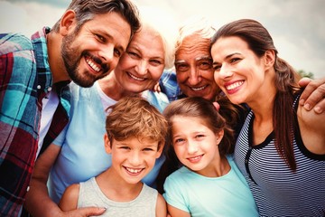 Happy multi generation family standing against sky