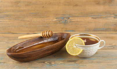 Tea with lemon and honey on the wooden background