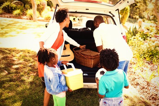 Happy Family Taking Objects Out Of The Car