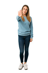 Full body of Blonde woman with blue shirt making stop gesture denying a situation that thinks wrong...