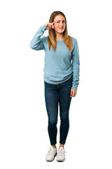 Full body of Blonde woman with blue shirt making the gesture of madness putting finger on the head on white background