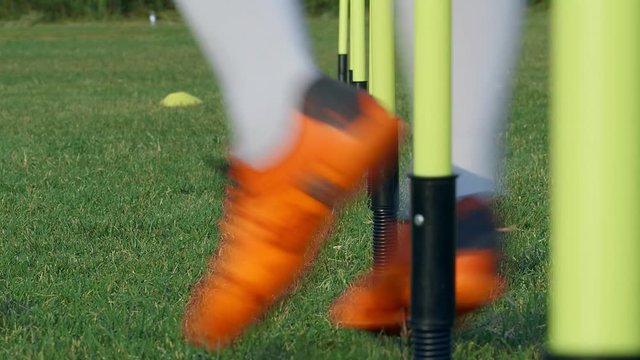 The feet of a player training with a soccer ball on a field, 4k slow motion