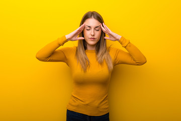 Young woman on yellow background unhappy and frustrated with something