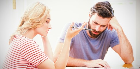 Worried young couple checking on bills