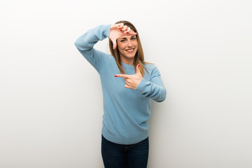 Fototapeta premium Blonde woman on isolated white background focusing face. Framing symbol