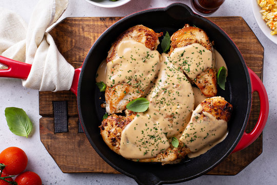 Cooked chicken breast seared in a cast iron skillet with creamy pan sauce