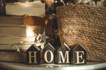 Home decorations in the wooden background of a letter with an inscription home. Christmas decorations and snow. Winter reading