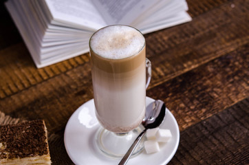 Glass latte with a book in the background
