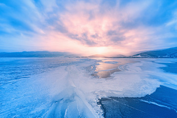 Frozen surface of Baikal lake at sunset.