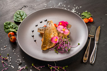 Fish fillet with vegetables on wooden background