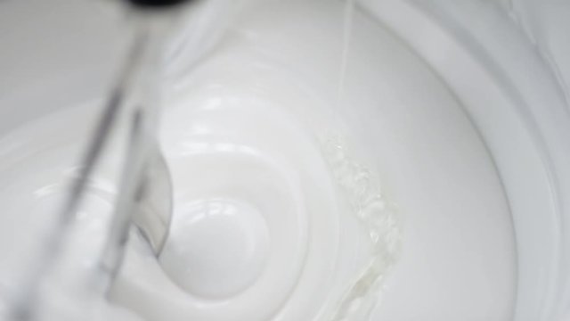 Transparent liquid is added into lab blender to a white cream