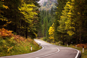 A road thru mountain pass in Dolomites during autumn with beautiful colors, Italy, Europe