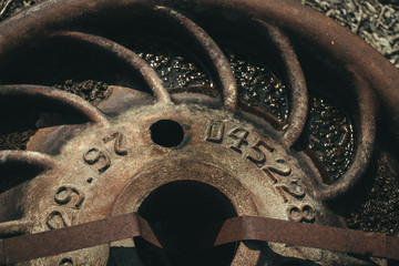 Close-up of an iron railroad car component laying on the ground.