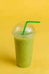 blended delicious drink from kiwi. close up photo. isolated yellow background. dessert from green fruits and vegetables