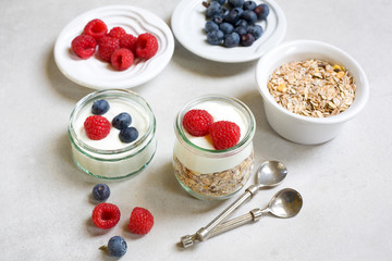 Healthy breakfast. Fresh raspberries and blueberries with yogurt and muesli.