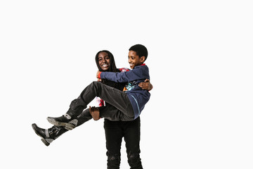 Smiling sister carrying her brother against white background