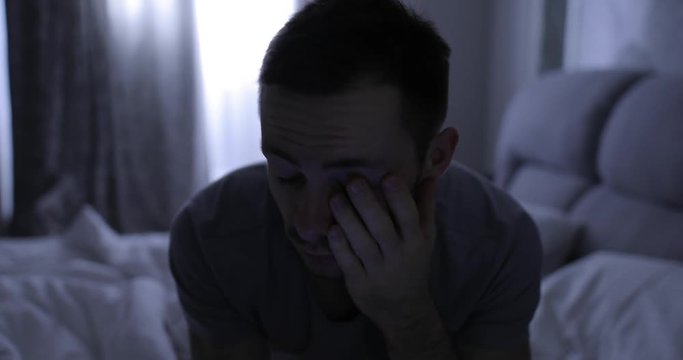 Depressed man in bed suffers from a symptom insomnia