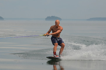 Guy Creating a Wake with a Wakeboard in Maine