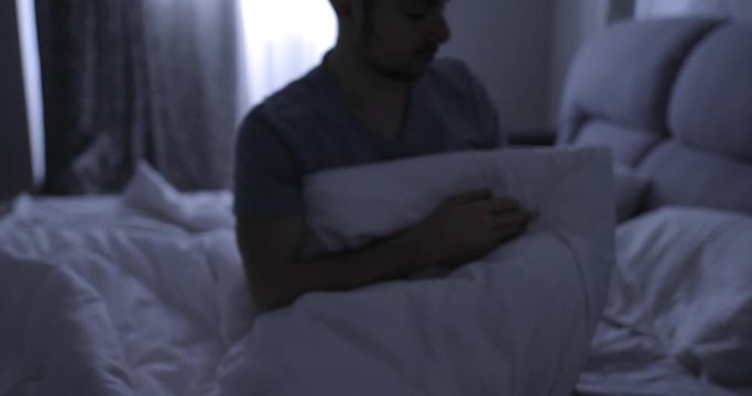 Depressed man in bed suffers from a symptom insomnia