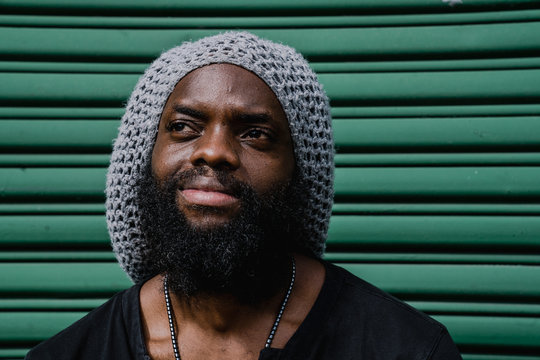 Close up of a thoughtful man sitting against roller shutter