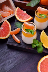 Creamy panna cotta and orange citrus jelly. Two layered dessert surrounded by fruits
