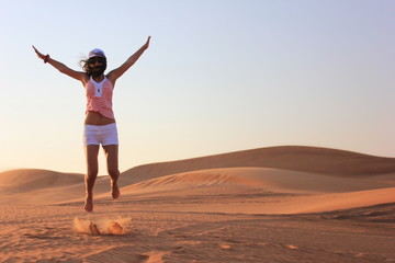 young woman jumping on the desert