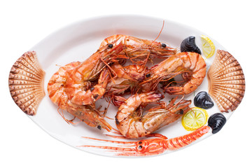 Seafood background. Closeup of fresh grilled big prawn tiger or shrimps on a colorful seafood plate isolated on a white background. Concept healthy food. BBQ.