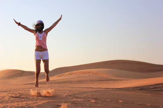 young woman jumping on the desert - Powered by Adobe