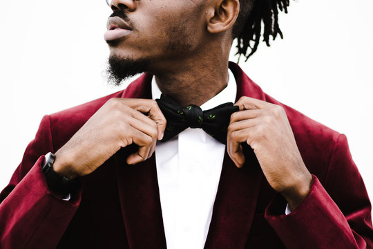 Midsection of young man adjusting bow tie