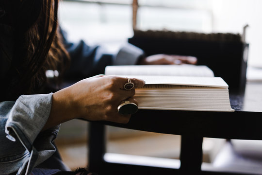 Midsection of woman reading book while sitting indoors