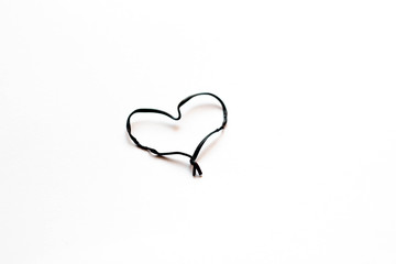 Black heart of wire on a white background. Valentine's Day.