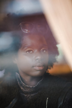 Portrait of girl looking through window