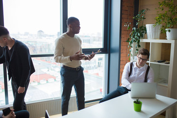 Multi ethnic business person group in casual wear listen to the Asian young man business officer explaining matter to his project team in modern office. Project and Business concept.