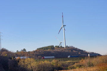 Wind turbines on blue sky. Production of clean and renewable energy. Trentino, Italy
