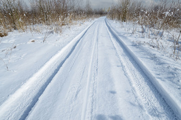 Fototapeta na wymiar Traces of the car in the snow.