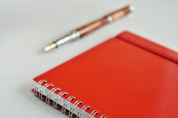 Red notebook with pencil