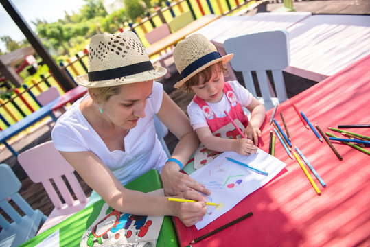 mom and little daughter drawing a colorful pictures