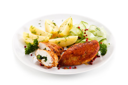 Stuffed chicken fillets and vegetables on white background