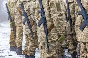 Story of military in camouflage with a firearm in winter