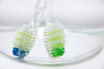 Colorful toothbrushes on a light background - obrazy, fototapety, plakaty