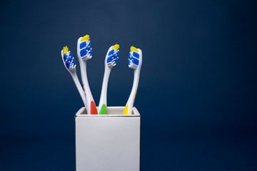 Colorful toothbrushes on a dark background - obrazy, fototapety, plakaty