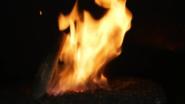 Pellet fire burn with spruce sawdust into the delivery strew bio wooden pallets to industrial modern boiler, sparks fly out and flames fire detail , biofuels made from compressed biomass fuel