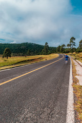 Man running in a road surrounded by trees