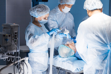 Team of experienced doctors and assistants performing difficult abdominal surgery, using the chance...