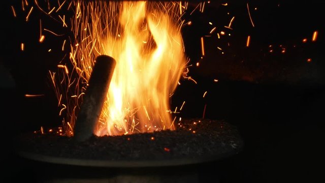 Pellets fire burn with spruce sawdust into the delivery strew bio wooden pallets to industrial modern boiler, sparks fly out and flames fire detail , biofuels made from compressed biomass fuel